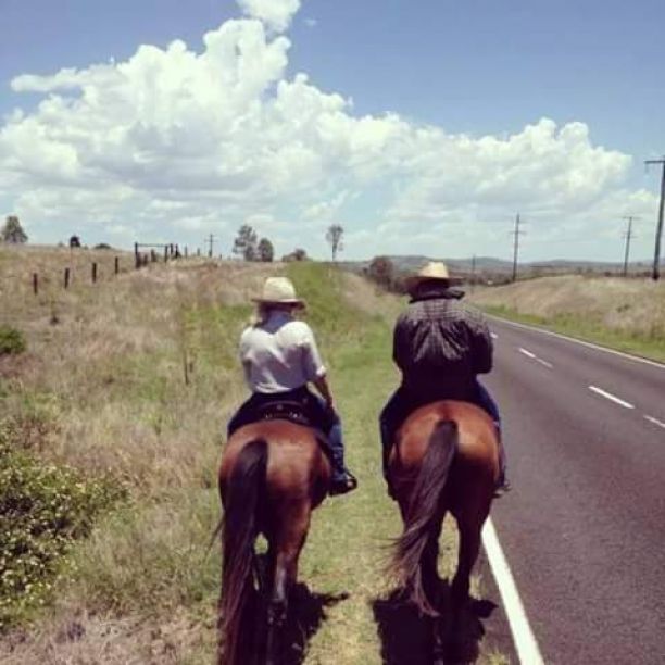 萨拉骑着马沿着路边在她的家族农场在昆士兰。