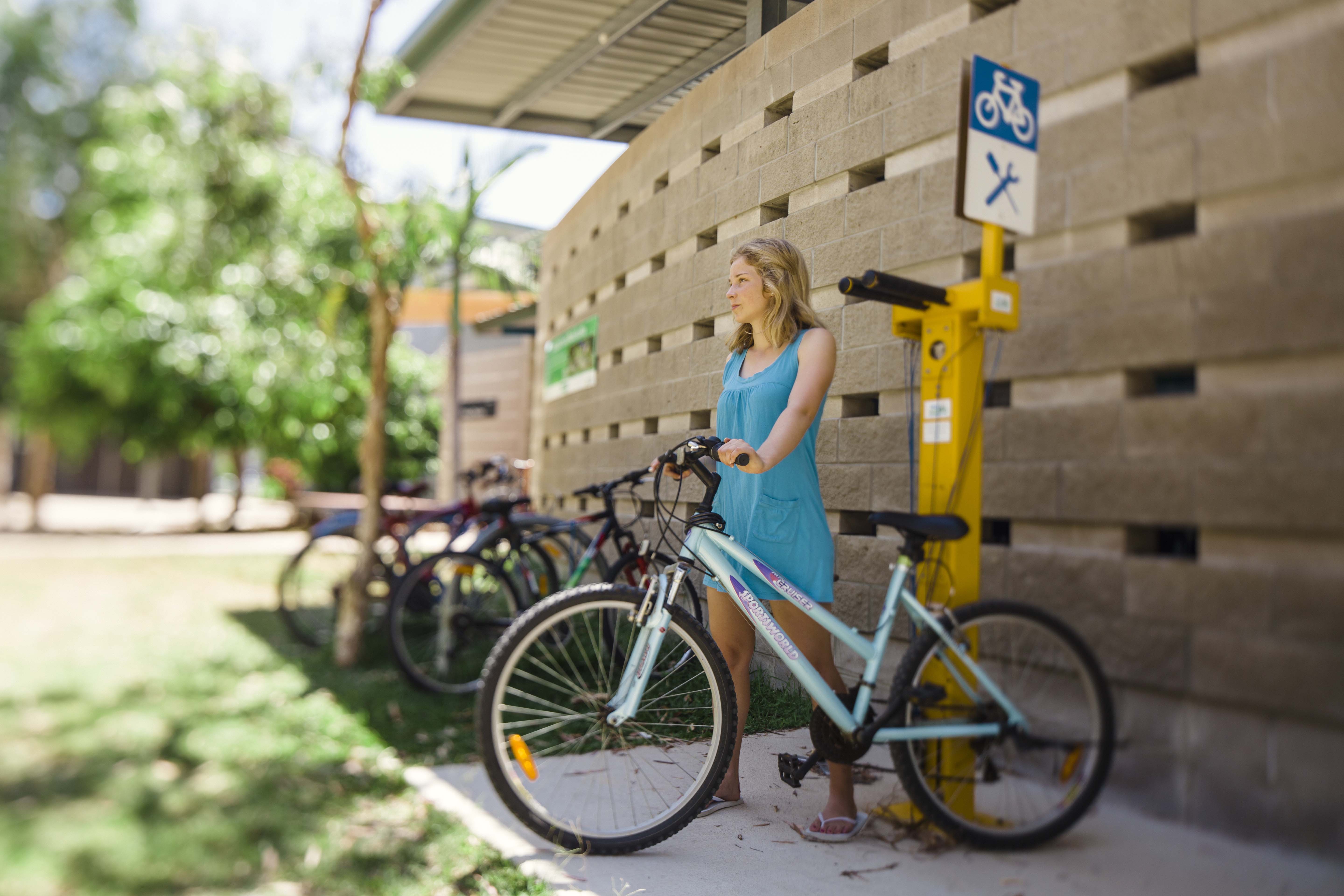 学生骑着山地车站在JCU自行车工作站前。
