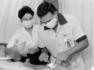 一名护理专业学生在临床教育人员的指导下进行伤口敷料