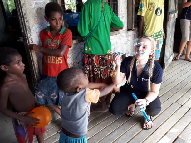 护理专业的学生和巴布亚新几内亚的孩子们一起玩耍